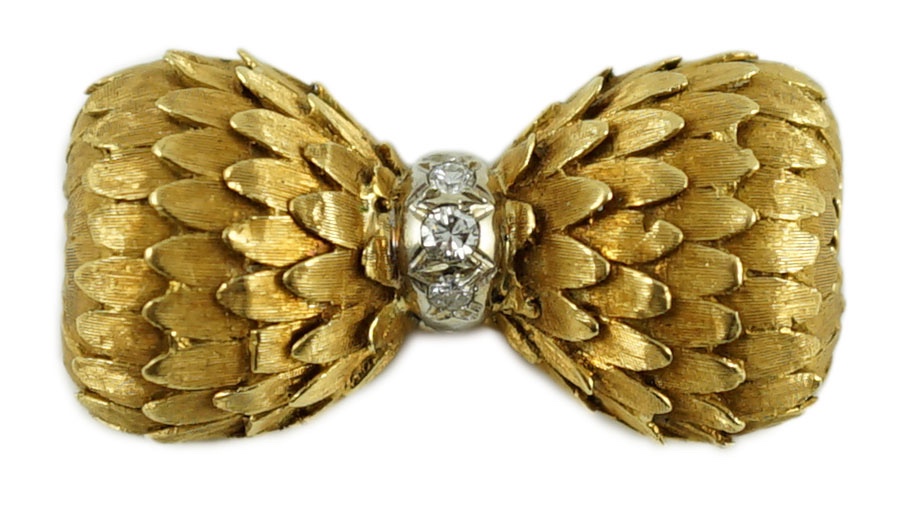 A stylish 1960's textured 18ct gold and three stone diamond set bow brooch